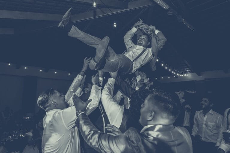 Groom lifted by the crowd on the dance floor